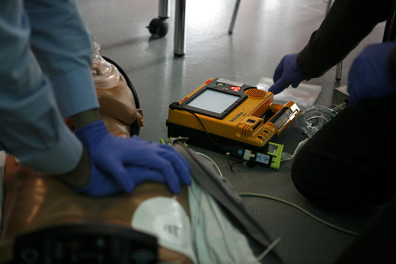 CPR training: CPR is being administered while a second rescuer prepares for defibrillation.