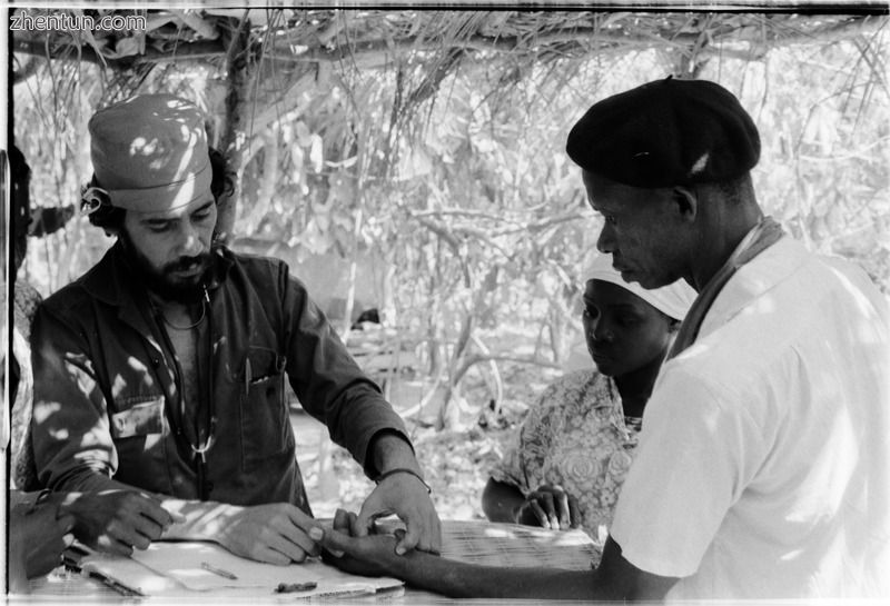 Cuban doctor checks the hand of a patient. Sara, Guinea-Bissau, liberated zones, 1974