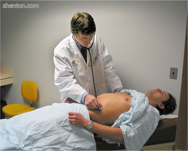 A doctor using a stethoscope to listen to a patient&#039;s abdomen.jpg
