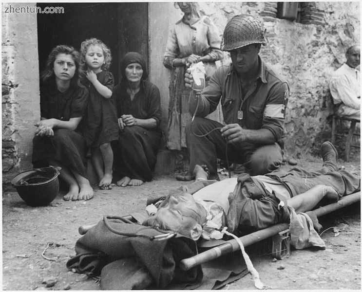 Private Roy W. Humphrey is being given blood plasma after he was wounded by shra.jpg